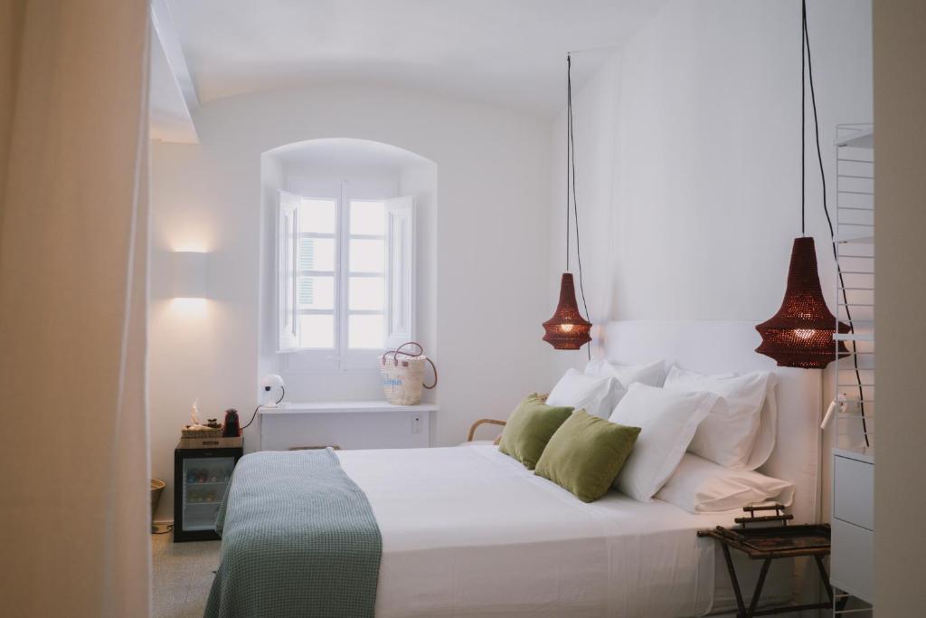卡达克斯Can Set的卧室配有白色床和绿色和白色枕头