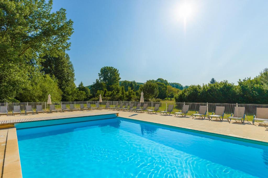 蒙蒂尼亚克Lagrange Vacances Les Bastides de Lascaux的一个带椅子和树木的大型蓝色游泳池