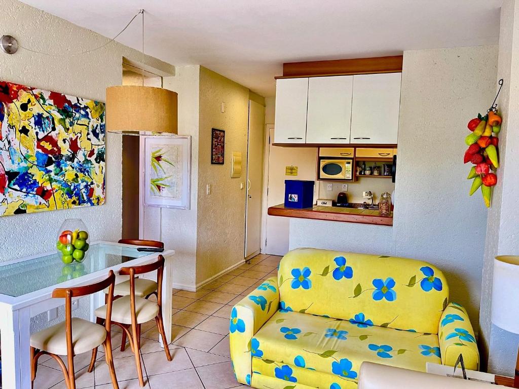 弗洛里亚诺波利斯Apartamento Dentro Resort Costao do Santinho NOT ALL INCLUSIVE的厨房以及带沙发和桌子的客厅。