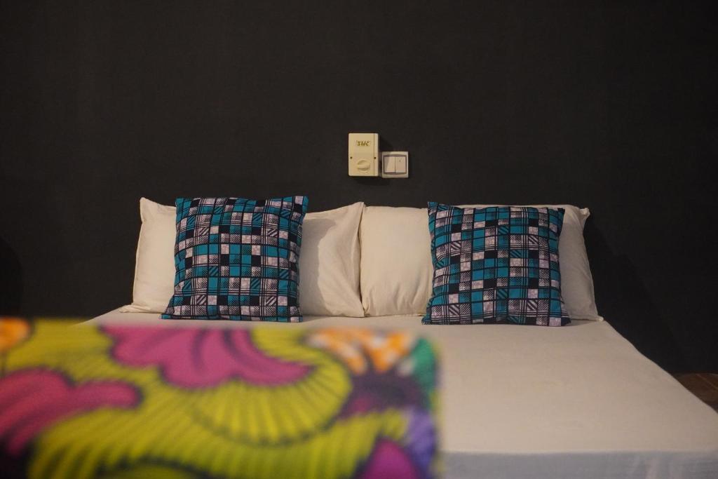 OuidahAu cœur de Ouidah 2的一间卧室配有一张带两个枕头的床