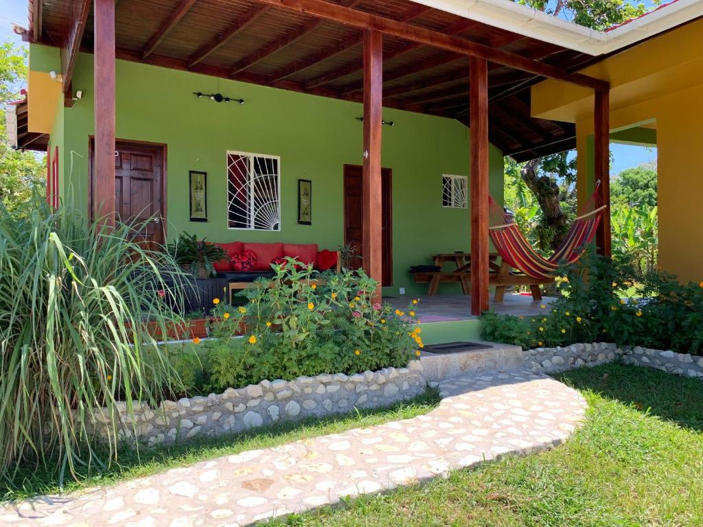 OracabessaGreen Queendom Farm and Lodging的院子里的绿色房子,有红色的沙发