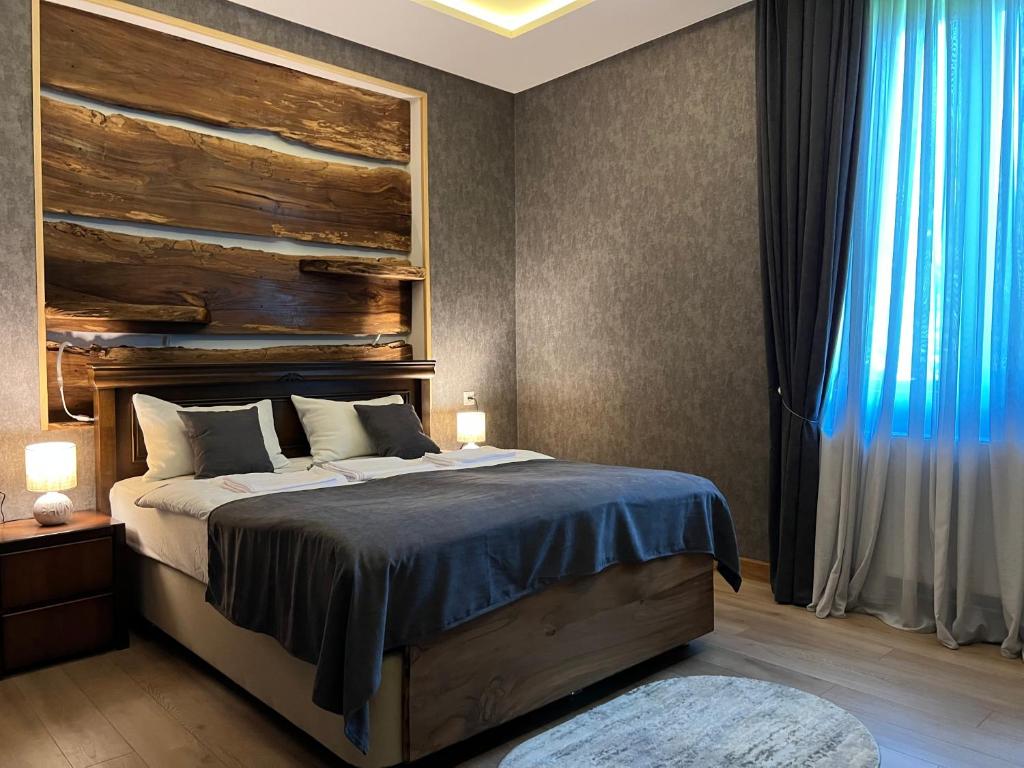 安布罗劳里Hotel Nordmann,Racha的一间卧室配有一张带木制床头板的床