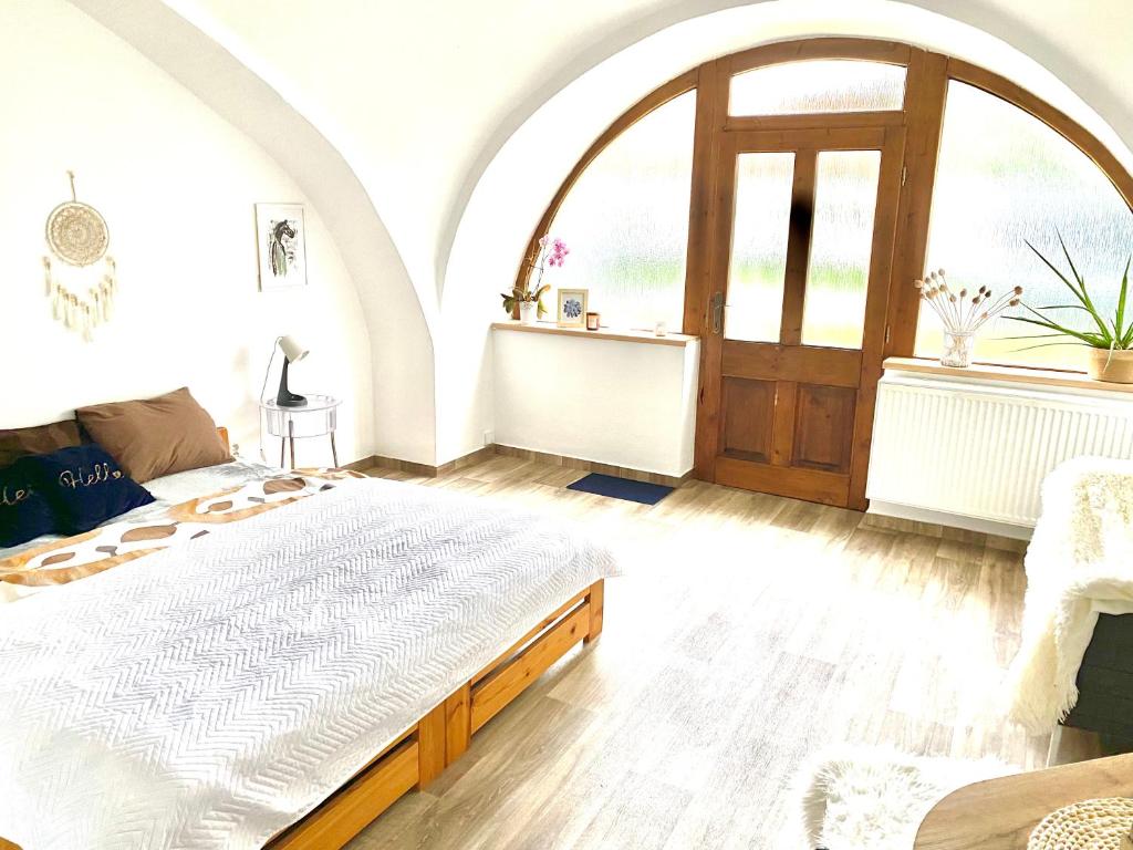 洛乌尼Apartmán v koňském areálu Židovice的一间卧室设有一张大床和一个大窗户