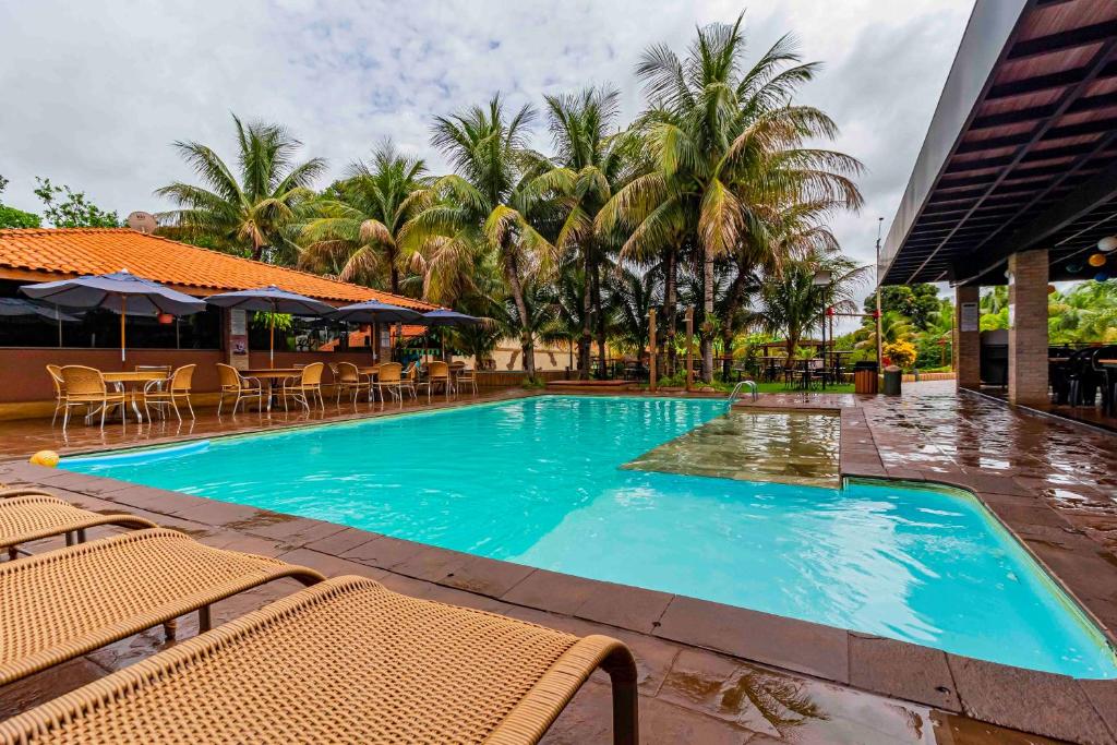 奥林匹亚Carpe Diem Eco Resort & SPA的一个带椅子和棕榈树的大型蓝色游泳池