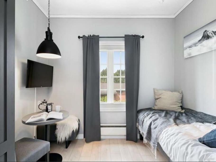 GarderStudio apt close to Airport的一间卧室配有一张床、一张桌子和一个窗户。