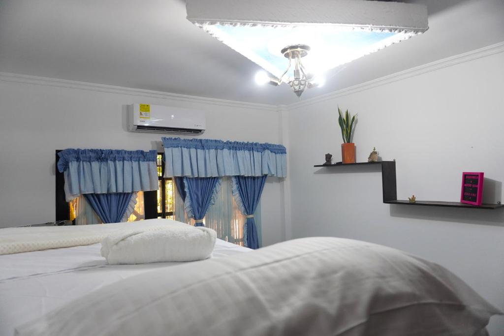 圣何塞德尔瓜维亚雷Hostal Castañeda的一间卧室配有白色的床和蓝色窗帘
