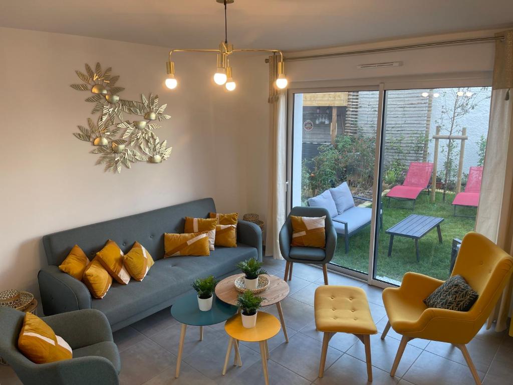 圣纳泽尔Villa des Cerisiers的客厅配有蓝色的沙发和椅子