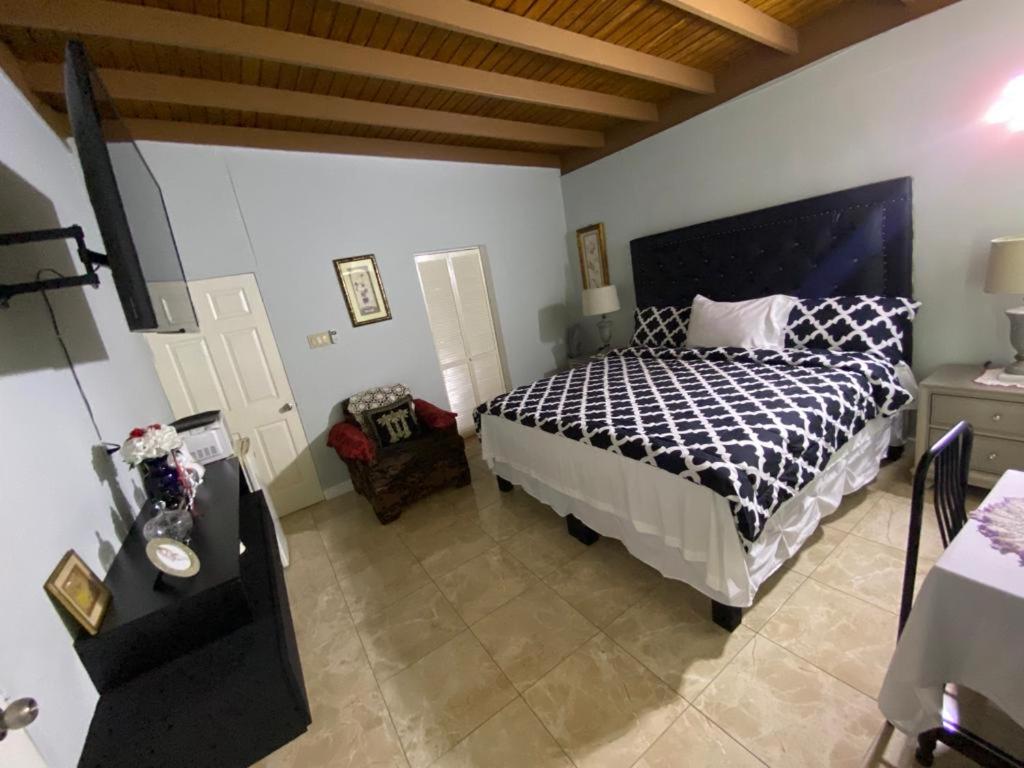 波特莫尔Portmore - Cheerful Private Bedroom with Fan only or AC - Choose your room的一间卧室配有一张带黑白色棉被的床