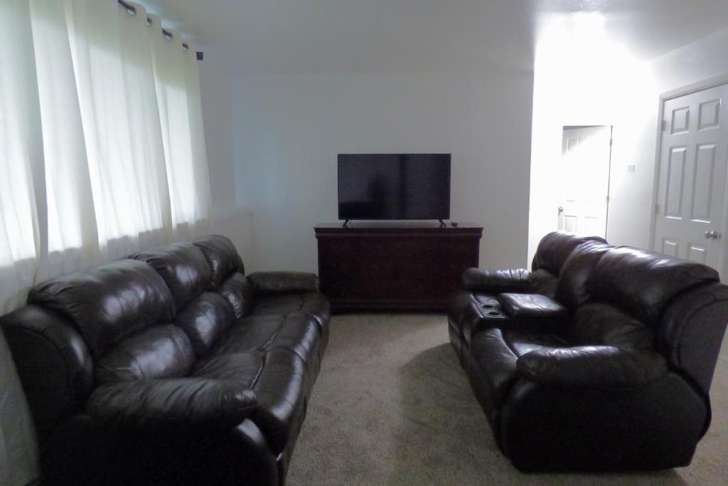 安克雷奇410 E 45th Unit 1的客厅配有真皮沙发和平面电视