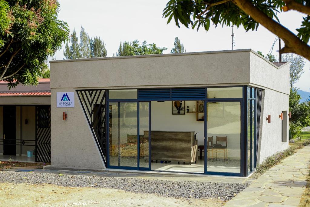 Maravilla Kivu Eco Resort的一座小房子,设有玻璃门和楼梯