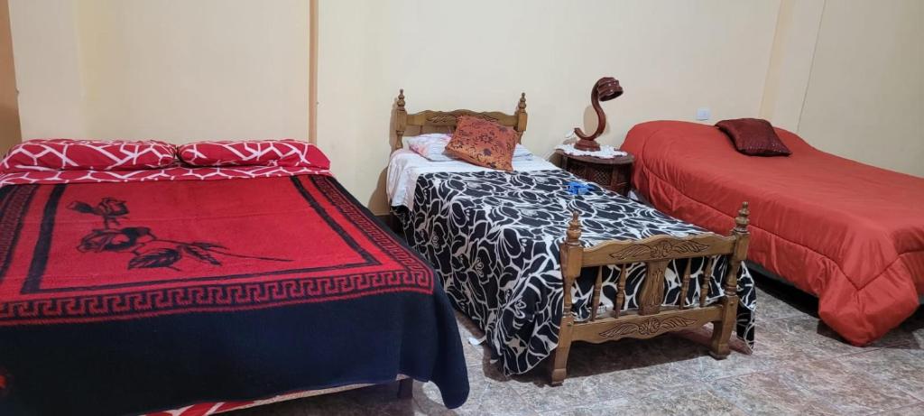 蒂诺加斯塔Kenny G的客房设有两张床和一张带床罩的桌子。