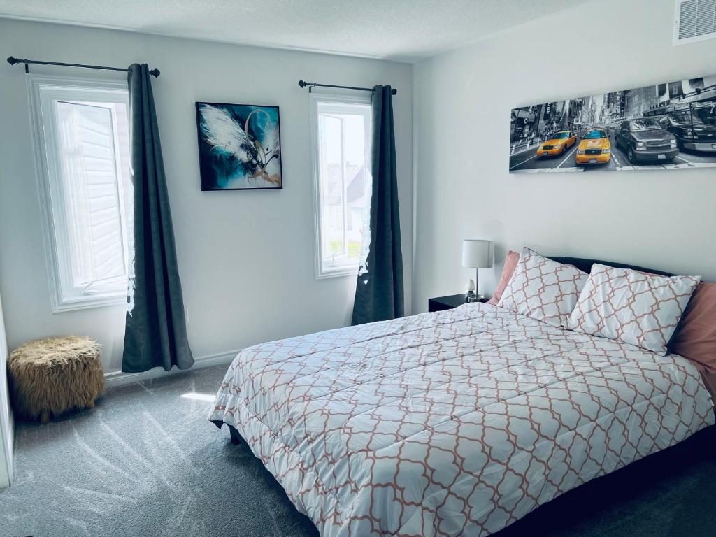 卡沃萨湖Brand new luxurious home, located in Lindsay.的一间卧室设有一张床和两个窗户。