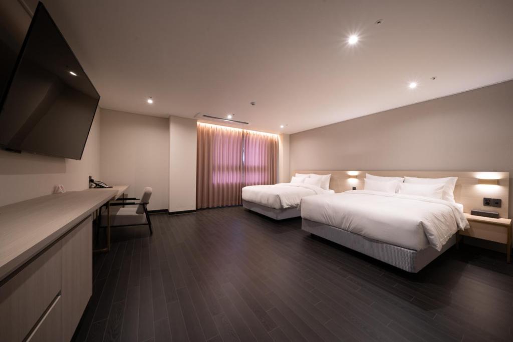 光州Hotel SUMMIT的酒店客房设有两张床和一台平面电视。