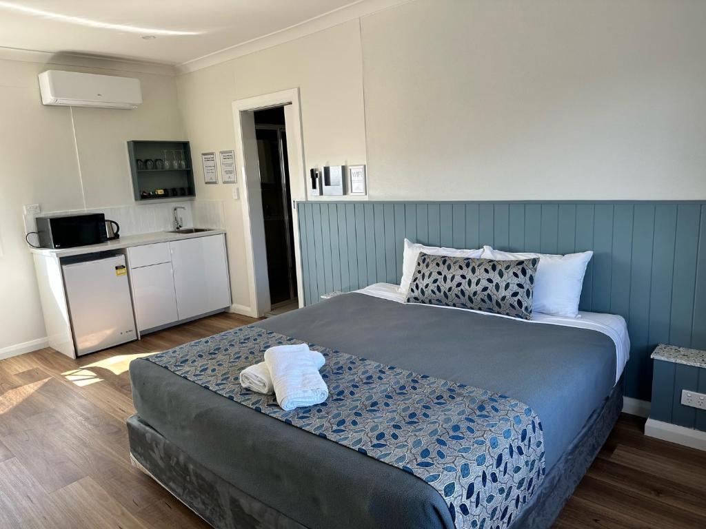 纽卡斯尔Surf Beach Motel Newcastle的一间带大床的卧室和一间厨房
