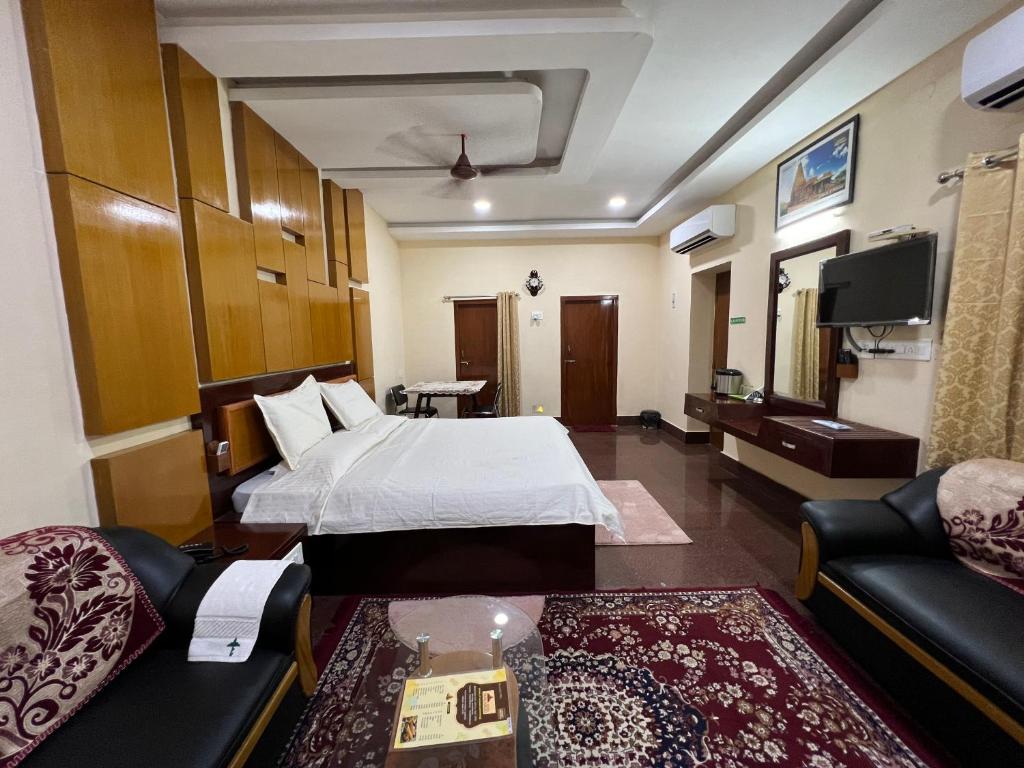 坦贾武尔Hotel TamilNadu - Thanjavur的酒店客房,配有床和沙发