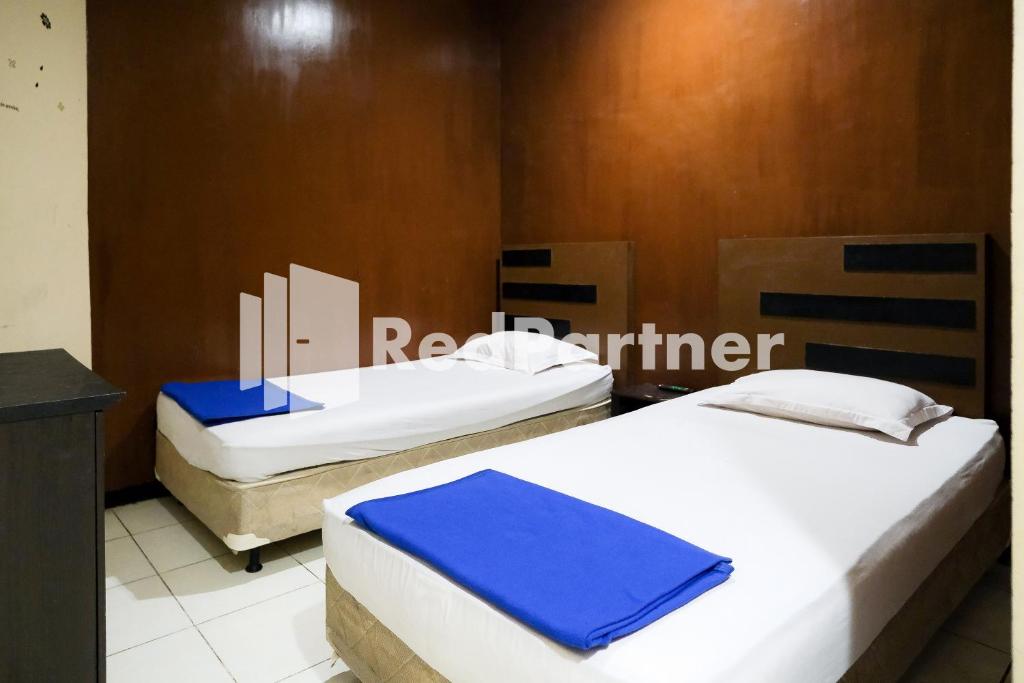 泗水RedDoorz at Sparkling Hotel Surabaya的一间客房内配有两张床的房间