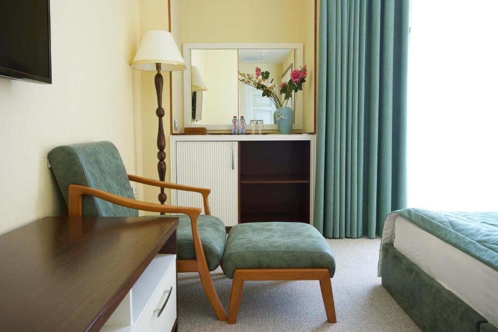 库萨雷ILK INN HOTEL的酒店客房带椅子和床
