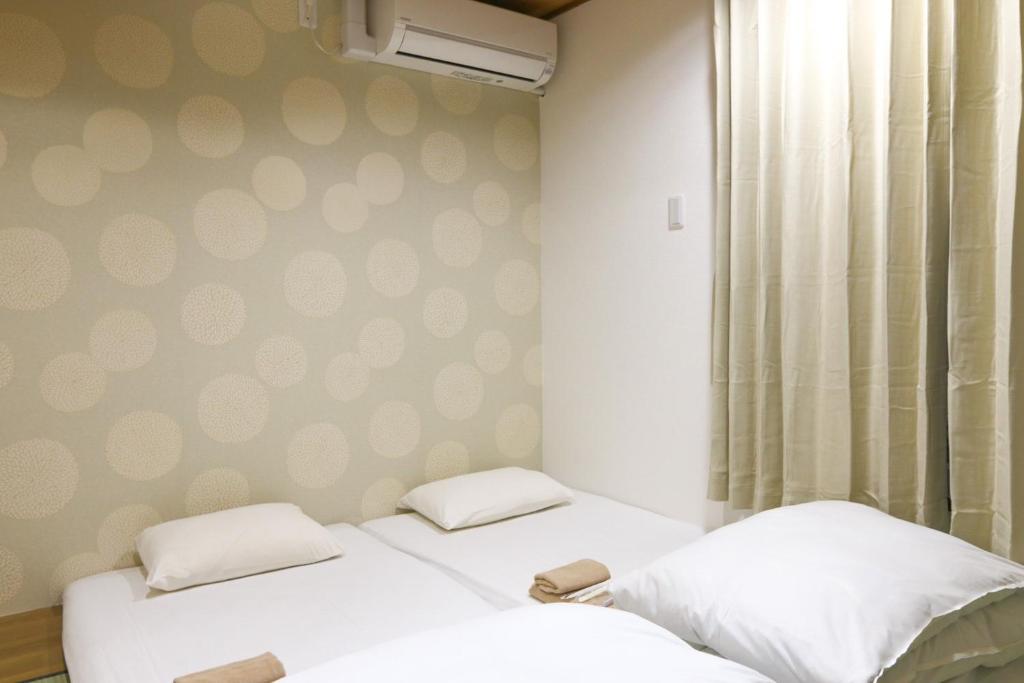 大阪Hotel Shin-Imamiya - Vacation STAY 36320v的墙上有圆点的两张床