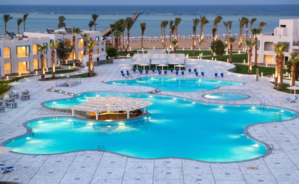 马萨阿拉姆Casa Blue Resort的享有棕榈树和海滩的度假泳池的顶部景致