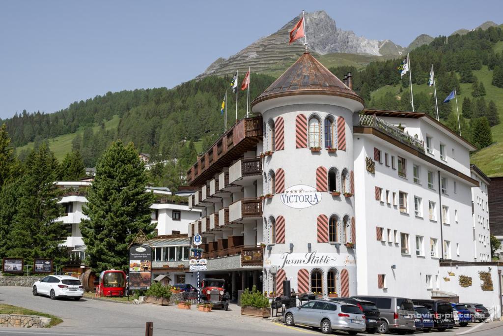 达沃斯Swiss Quality Turmhotel Victoria的山间酒店,门前有车辆停放