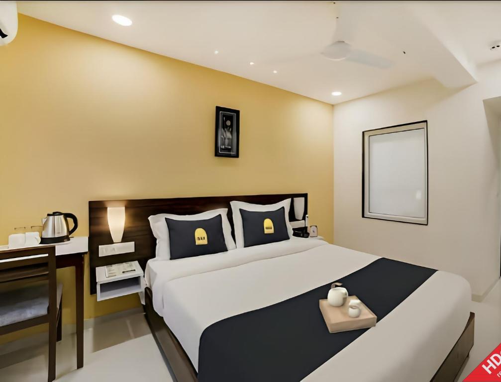 艾哈迈达巴德Leo Hotel的一间卧室配有一张大床和一张书桌