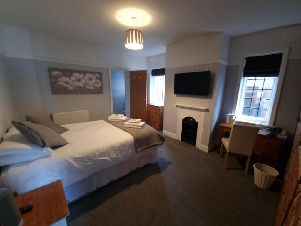 南安普敦The Bugle Inn的一间卧室配有一张床、一张书桌和一台电视