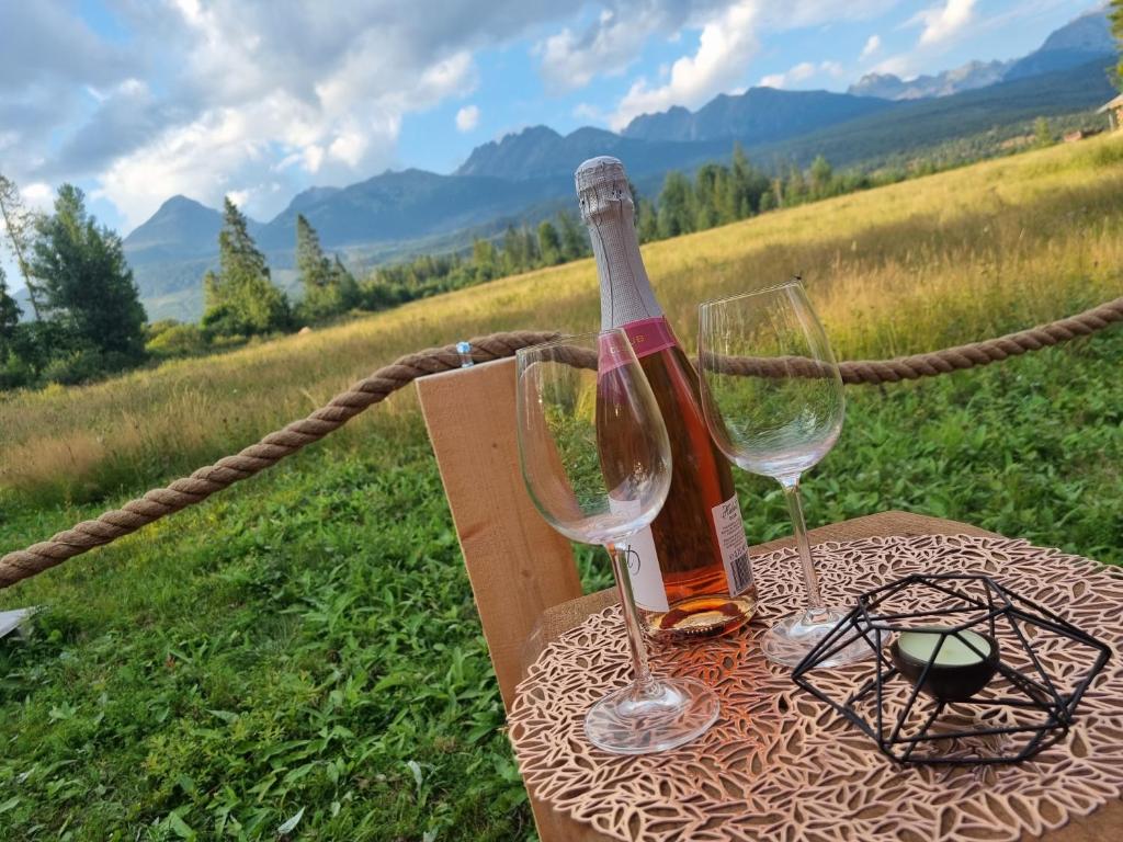 VažecDomčok pod Tatrami的桌子上放有一瓶葡萄酒和两杯酒