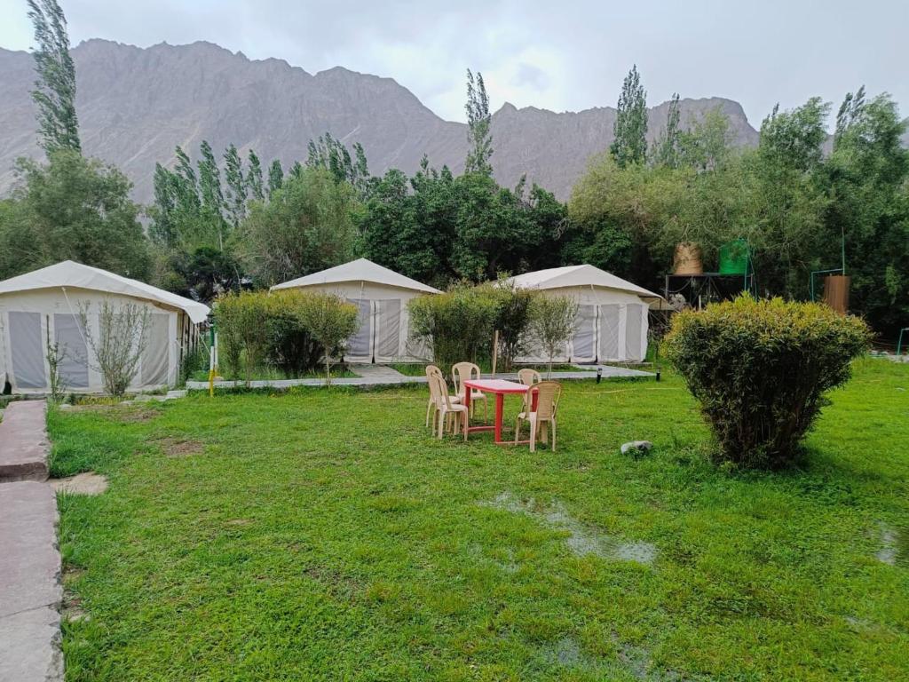 洪达尔The Mountain Camp - Nubra的一个带桌椅和帐篷的庭院