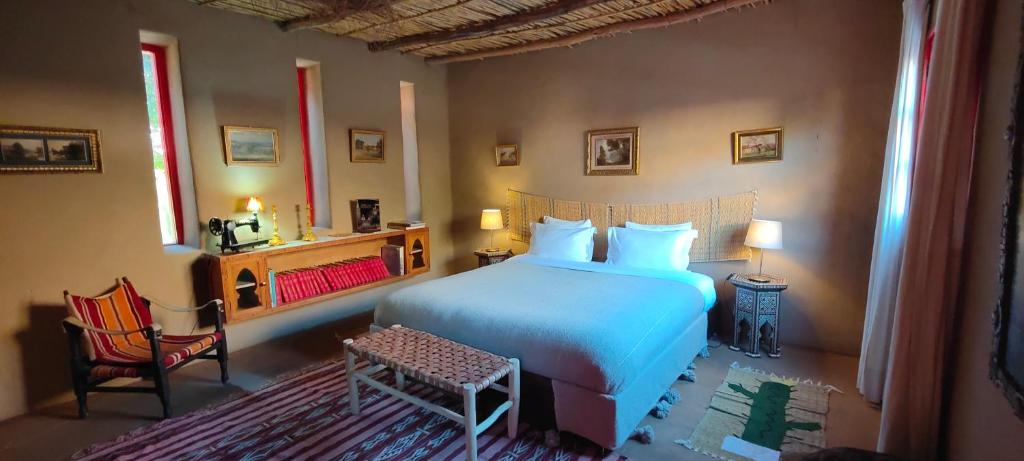 达赫拉Dar Tawarta Guest House Dakhla的卧室配有白色的床和椅子