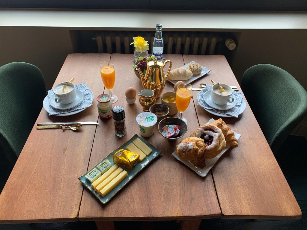 根特Maison d'Artiste的一张木桌,上面摆放着早餐食品和饮料