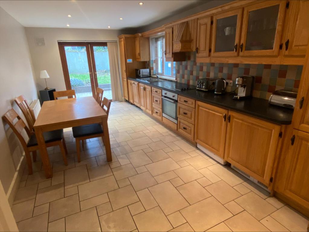 戈尔韦Cosy 4 Bedroom Galway House with Rear Garden Patio的厨房配有木制橱柜和桌椅