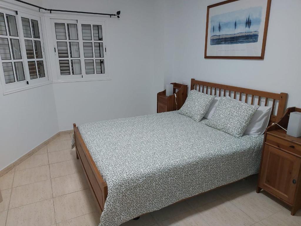 维辛达里奥NIVARIA SUITE的一间卧室设有一张床和一个窗口