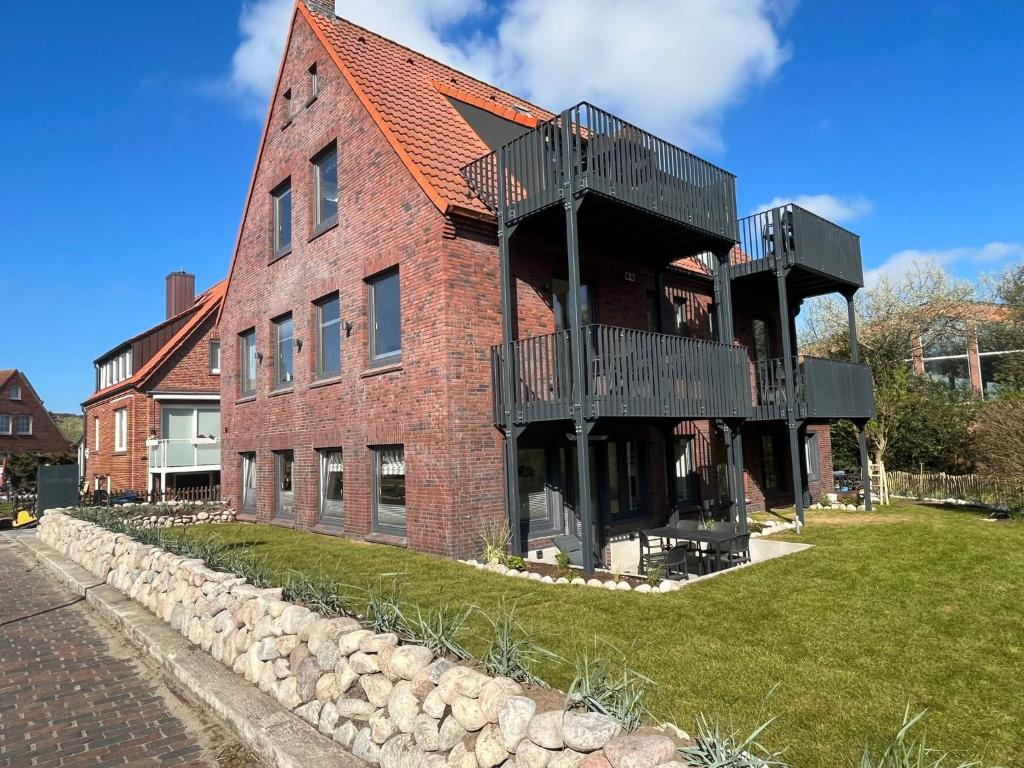 于斯德Dünen Lodge 3的一面设有一面阳台的砖砌建筑
