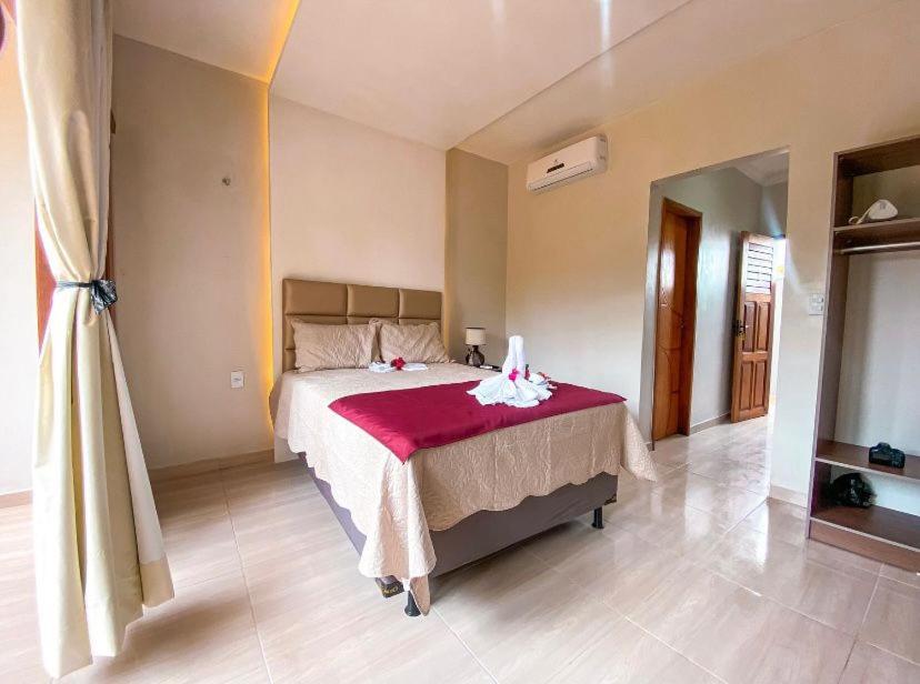 杰里科科拉Deu Praia Pousada的一间卧室配有一张带红色毯子的大床