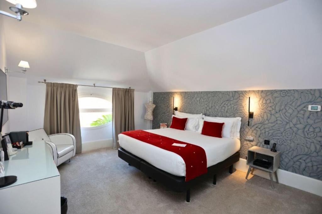 马拉加马拉加马里波萨酒店的酒店客房配有一张带红色枕头的大床