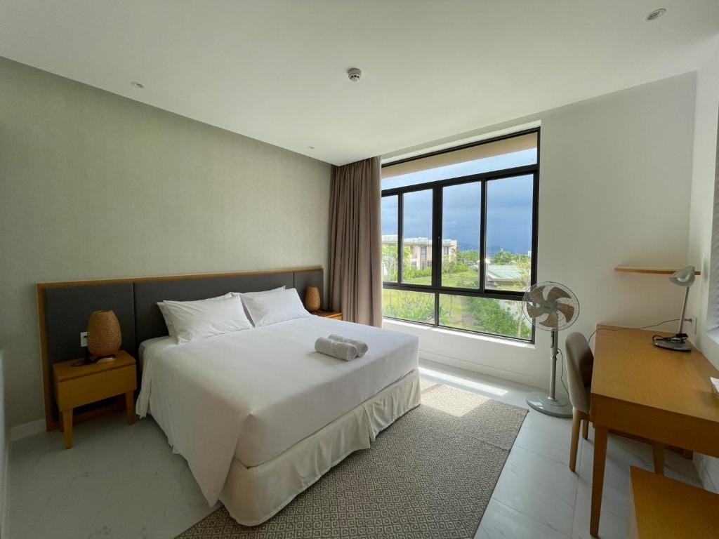 芽庄Cam Ranh Villa的卧室设有白色的床和大窗户