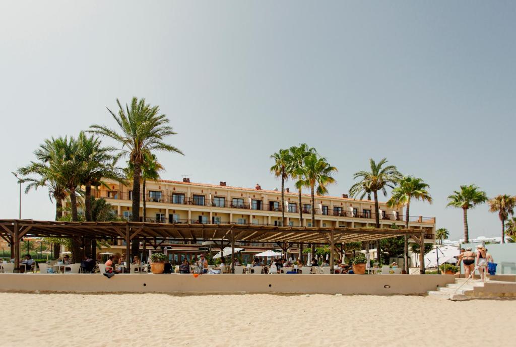 德尼亚Hotel Los Ángeles Denia的棕榈树掩映的海滩上酒店