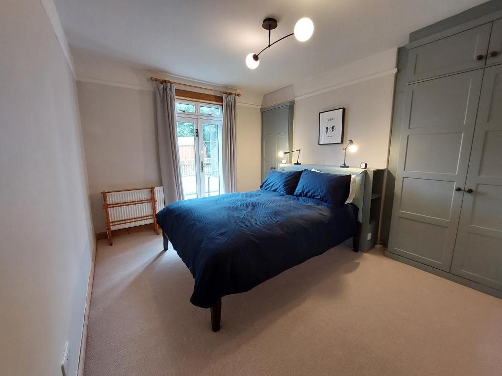 因纳利森Cosy flat in Innerleithen的一间卧室配有一张带蓝色床单的床和一扇窗户。