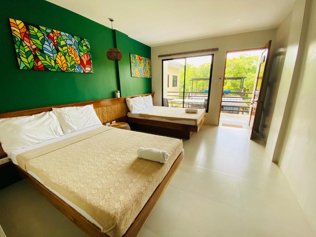 班塔延岛TEZA Resort的一间卧室设有两张床和绿色的墙壁