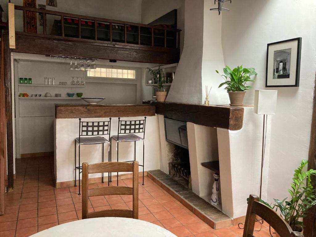 普罗旺斯艾克斯Le Cardinale - Un Voyage en Provence的厨房配有壁炉、2把椅子和1张桌子