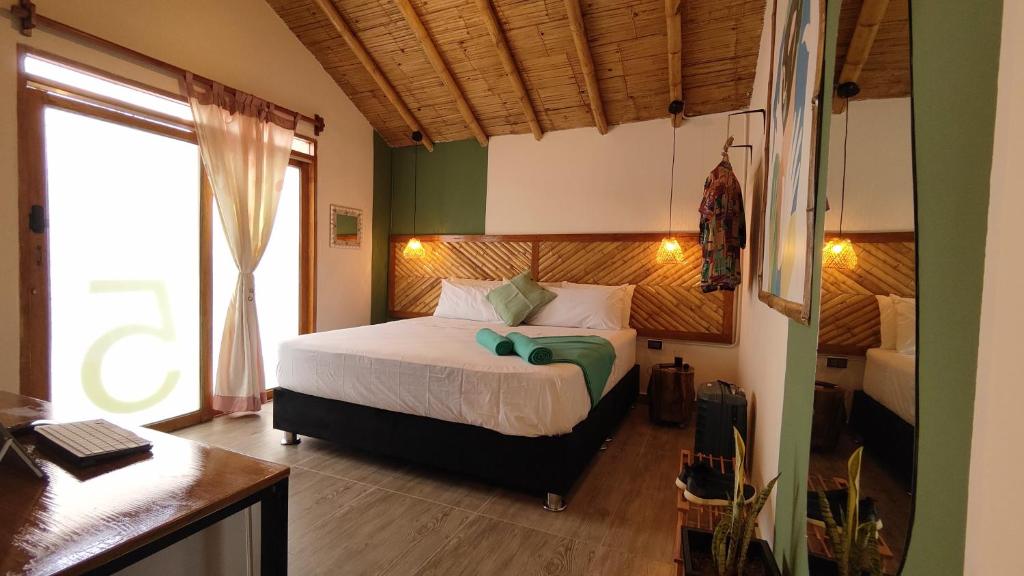 曼克拉Puerto Bamboo的一间卧室配有一张床、一张书桌和一个窗户。