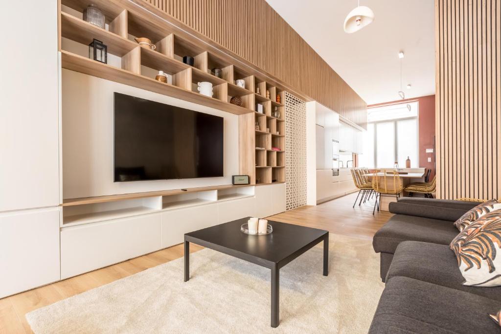 里尔Luxueux Logement Design 4 ch Climatisé的客厅配有电视、沙发和桌子