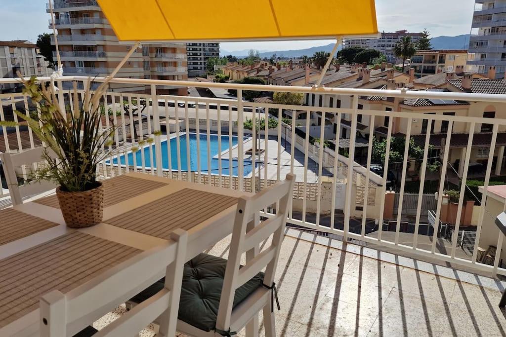 贝尼卡西姆Apartamento de playa en paseo marítimo的一个带遮阳伞和游泳池的阳台