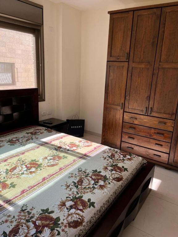 纳布卢斯Salah Khamlan Apartments的一间卧室设有两张床和木制橱柜