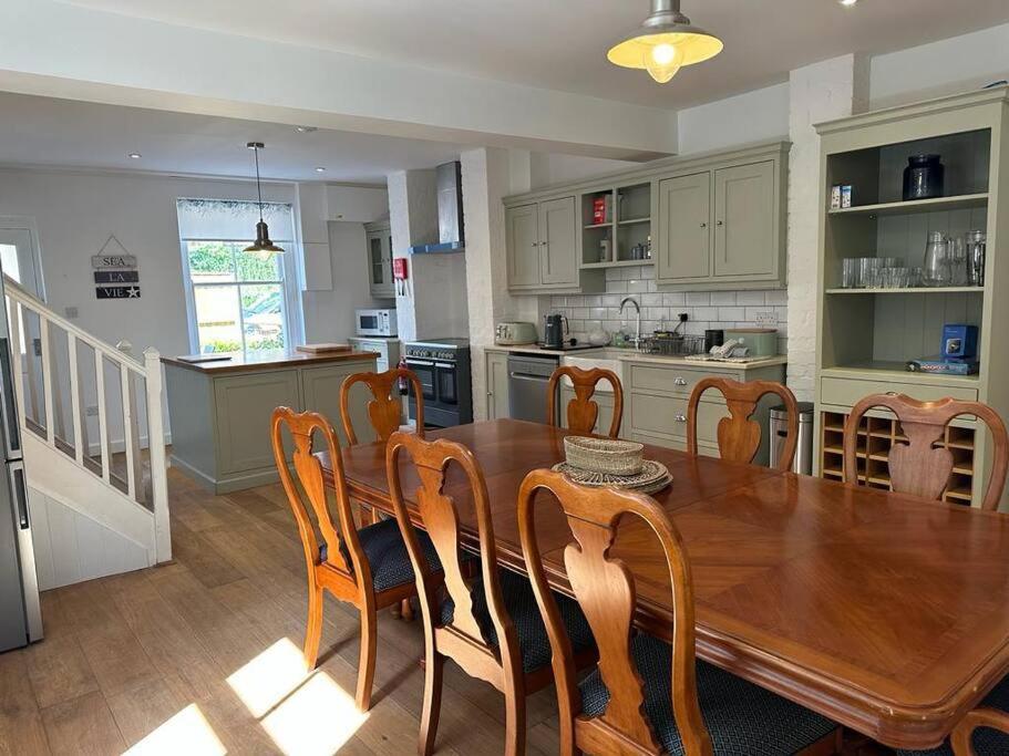 达特茅斯Home in Dartmouth, Devon with Private Parking的厨房以及带木桌和椅子的用餐室。