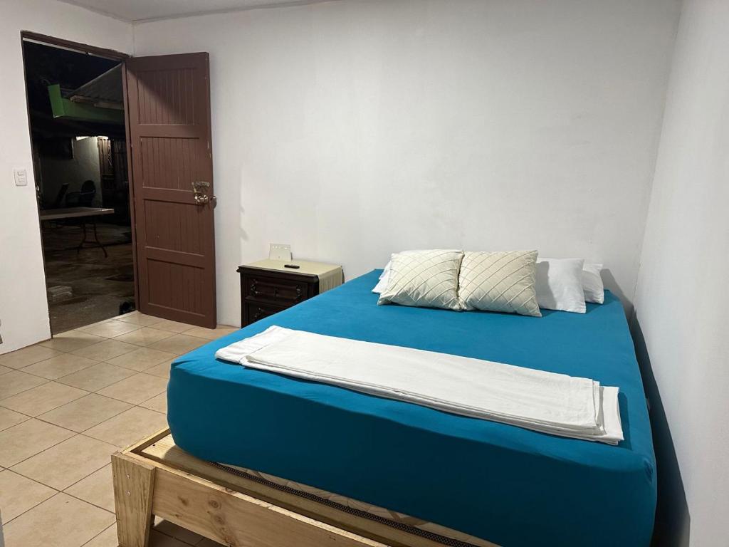利比里亚Puente Real Hostel的一间卧室配有一张带蓝色床单的床和一扇门。