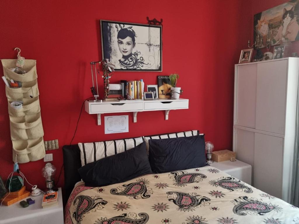 蒙特卡罗Milo's house的一间卧室设有一张床和红色的墙壁