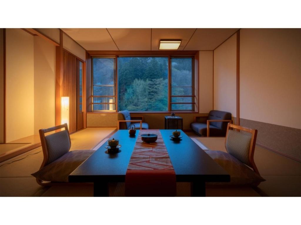 雫石町Oshuku Onsen Choeikan - Vacation STAY 55578v的客房设有桌椅和大窗户。