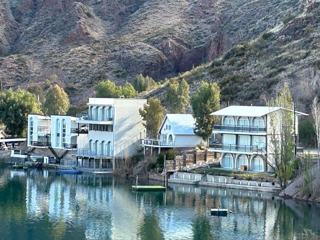 圣拉斐尔Casa en Los Reyunos, Ubicación perfecta Frente al lago的山边水面上的建筑