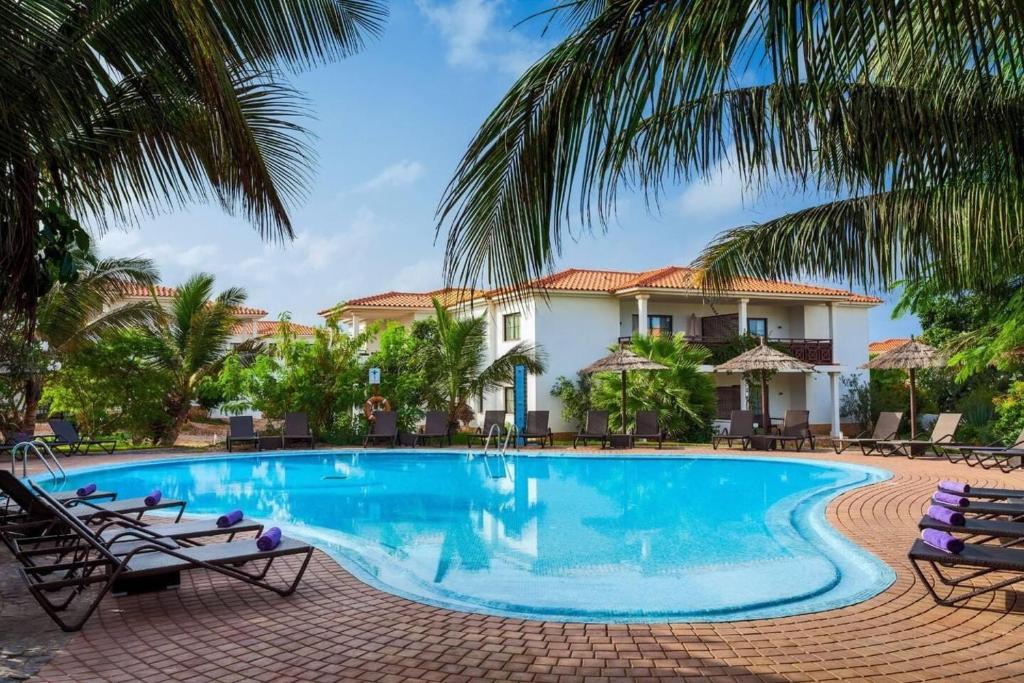 圣玛丽亚Tortuga beach lovely 2 bed apartment and gardens的棕榈树屋前的游泳池